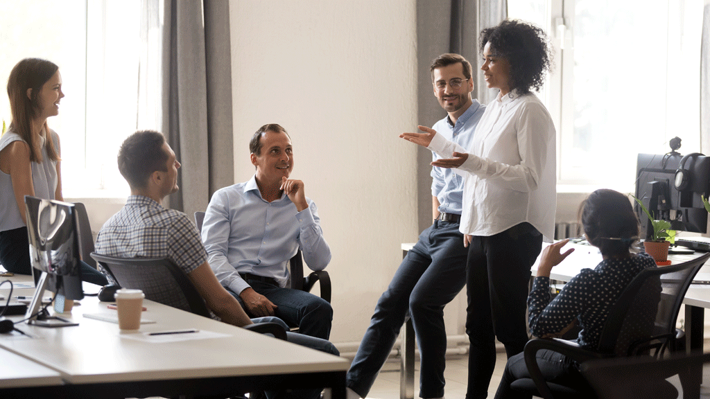 Deux collègues discutant des relances clients devant un écran de suivi